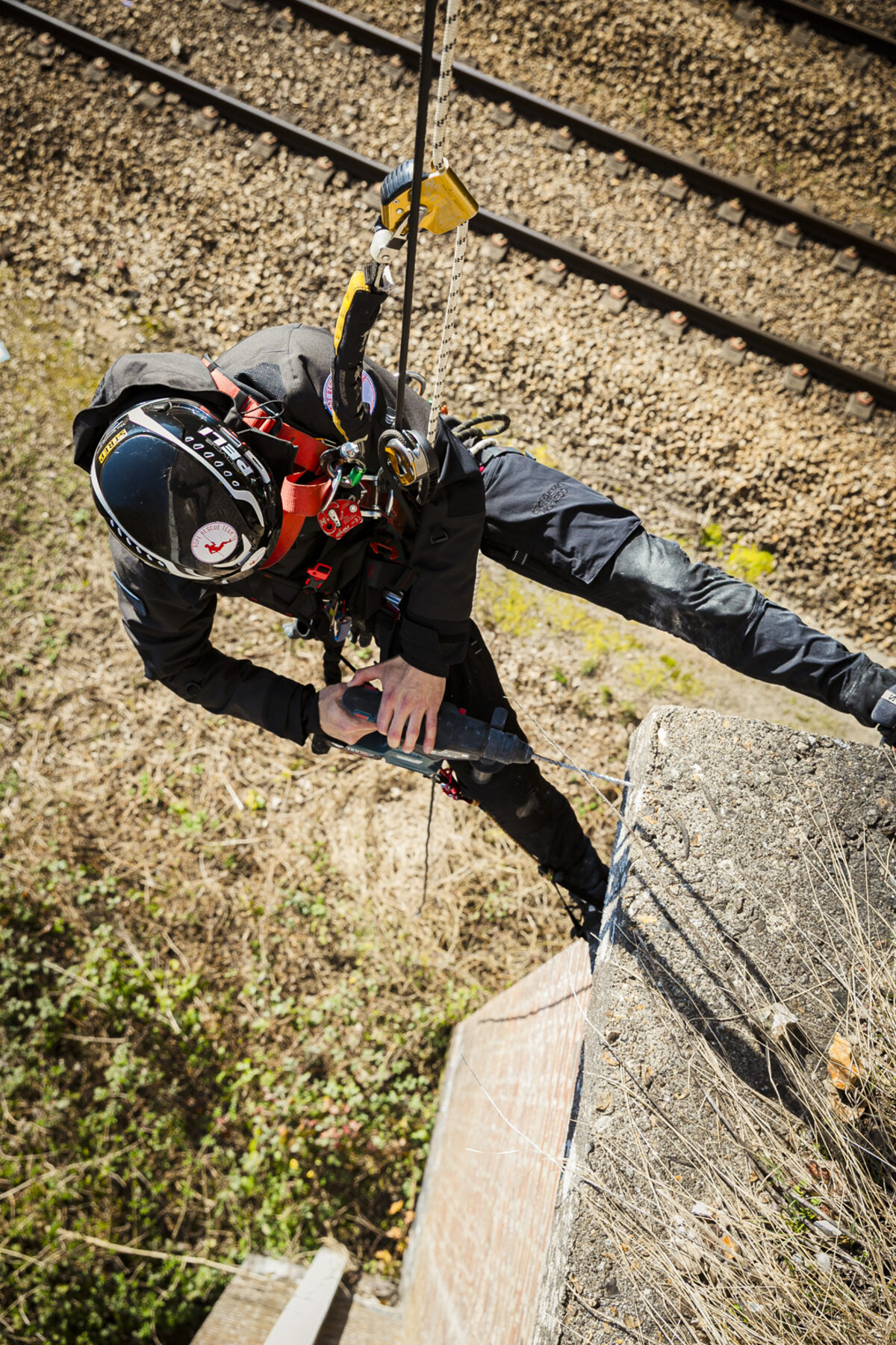 Rope access technician in Extreme Access workwear working above a steel rail