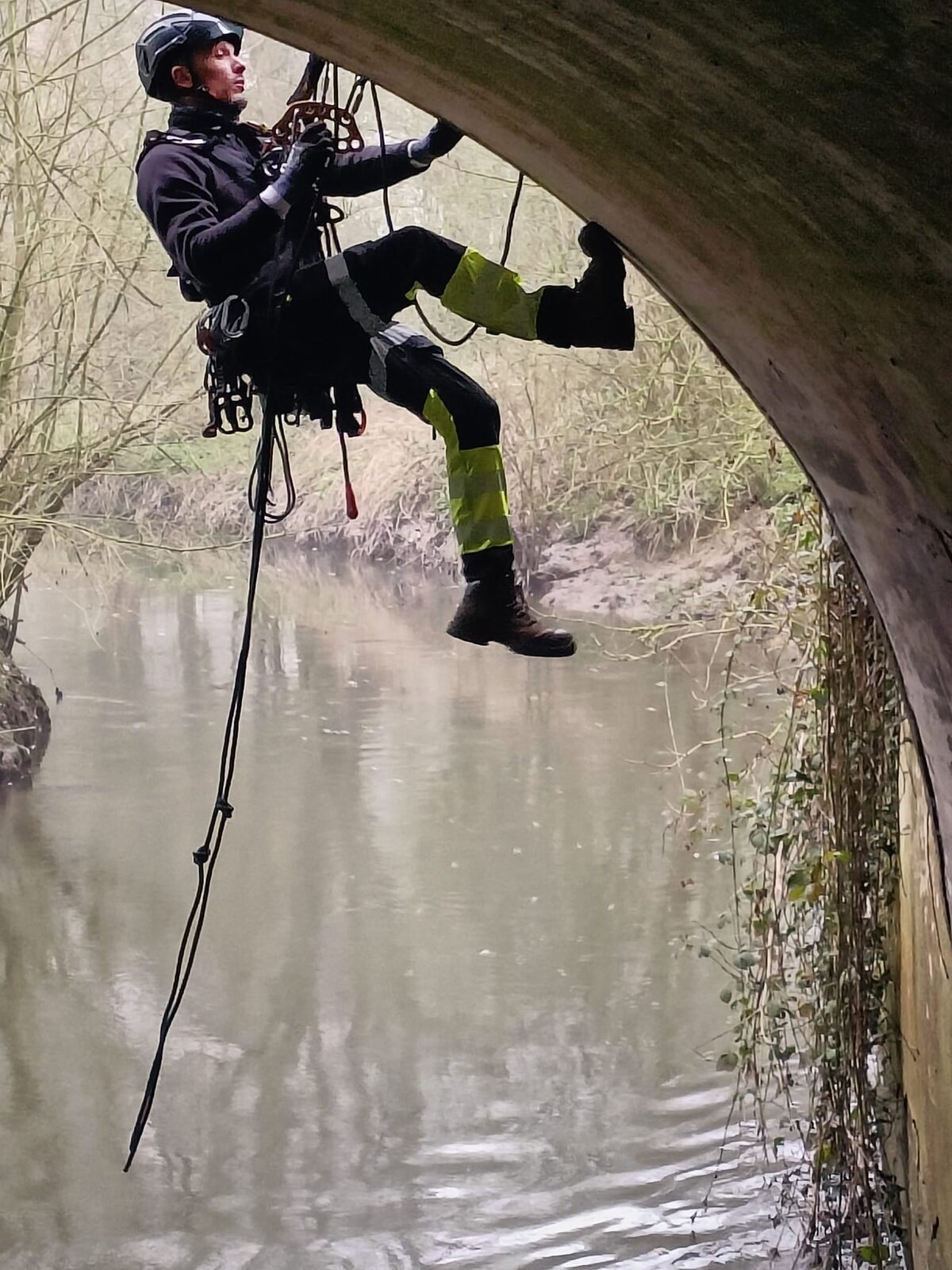Technician suspended in a harness wearing fitted Extreme Access workwear