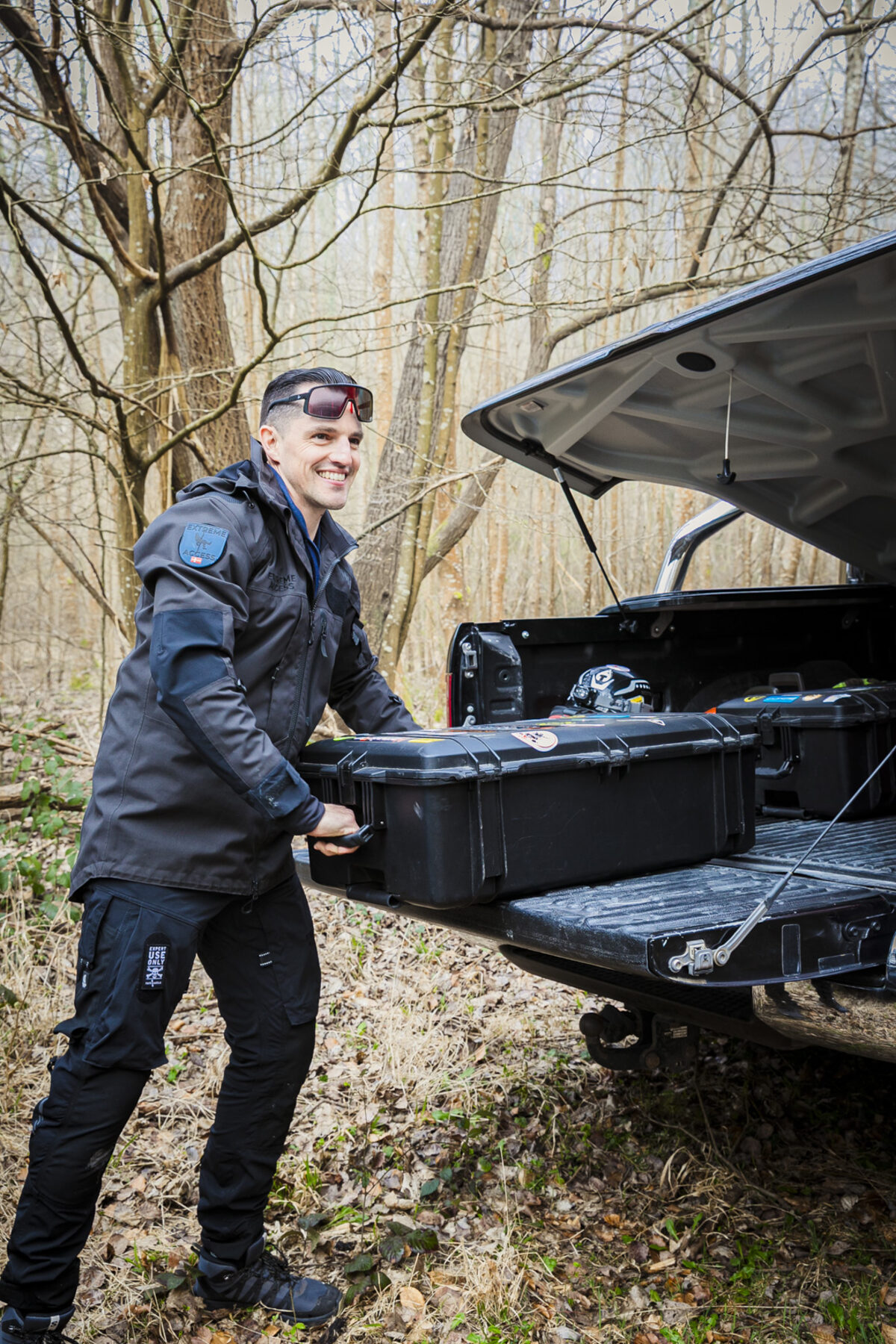 Extreme Access team member preparing equipment beside a vehicle